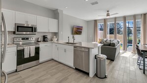 Una cocina moderna con armarios blancos, electrodomésticos de acero inoxidable y una isla grande.