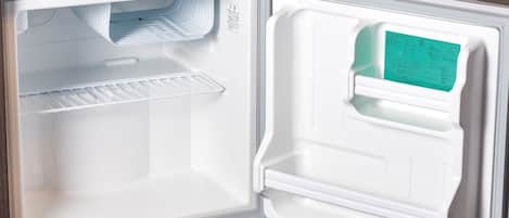 An open refrigerator with a control panel on the right side and a shelf on the left.