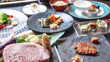 A variety of dishes on a table, including meat, vegetables, and seafood.