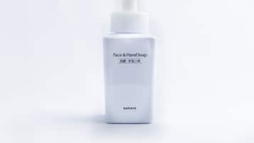A white bottle of face and hand soap with a pump dispenser.