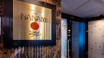Letrero para el Restaurante Tepanyaki con un diseño estilizado de sol y ramas.