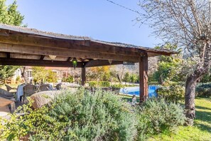 A covered patio area with outdoor furniture, a pool, and a garden. - Family Country House with Pool in Andratx (Port Andratx)