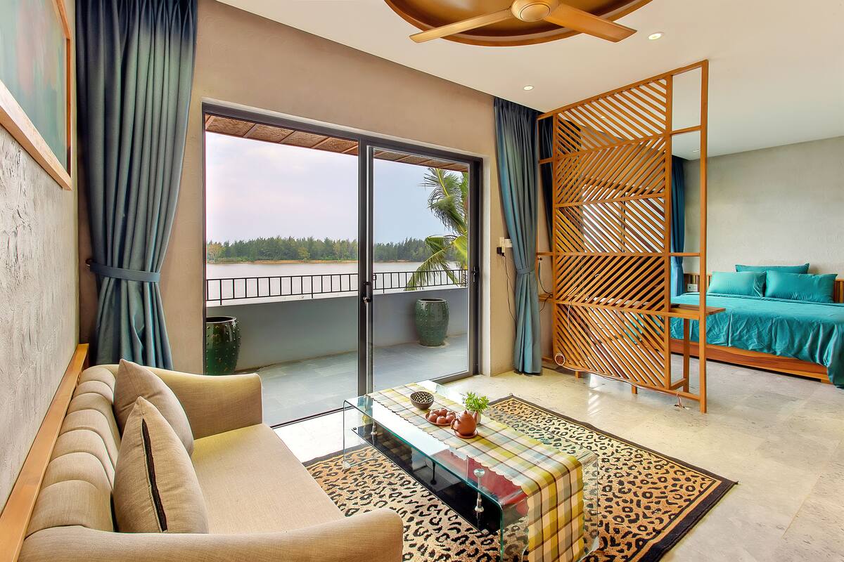 A modern living room with a sofa, a glass coffee table, and a view of a balcony with a railing.