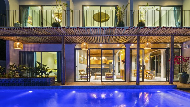 Zona junto a la piscina con un área de estar techada, un espacio para comer y vistas a la piscina.