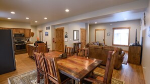 A spacious kitchen with wooden cabinets and a dining area with a large wooden table and chairs.