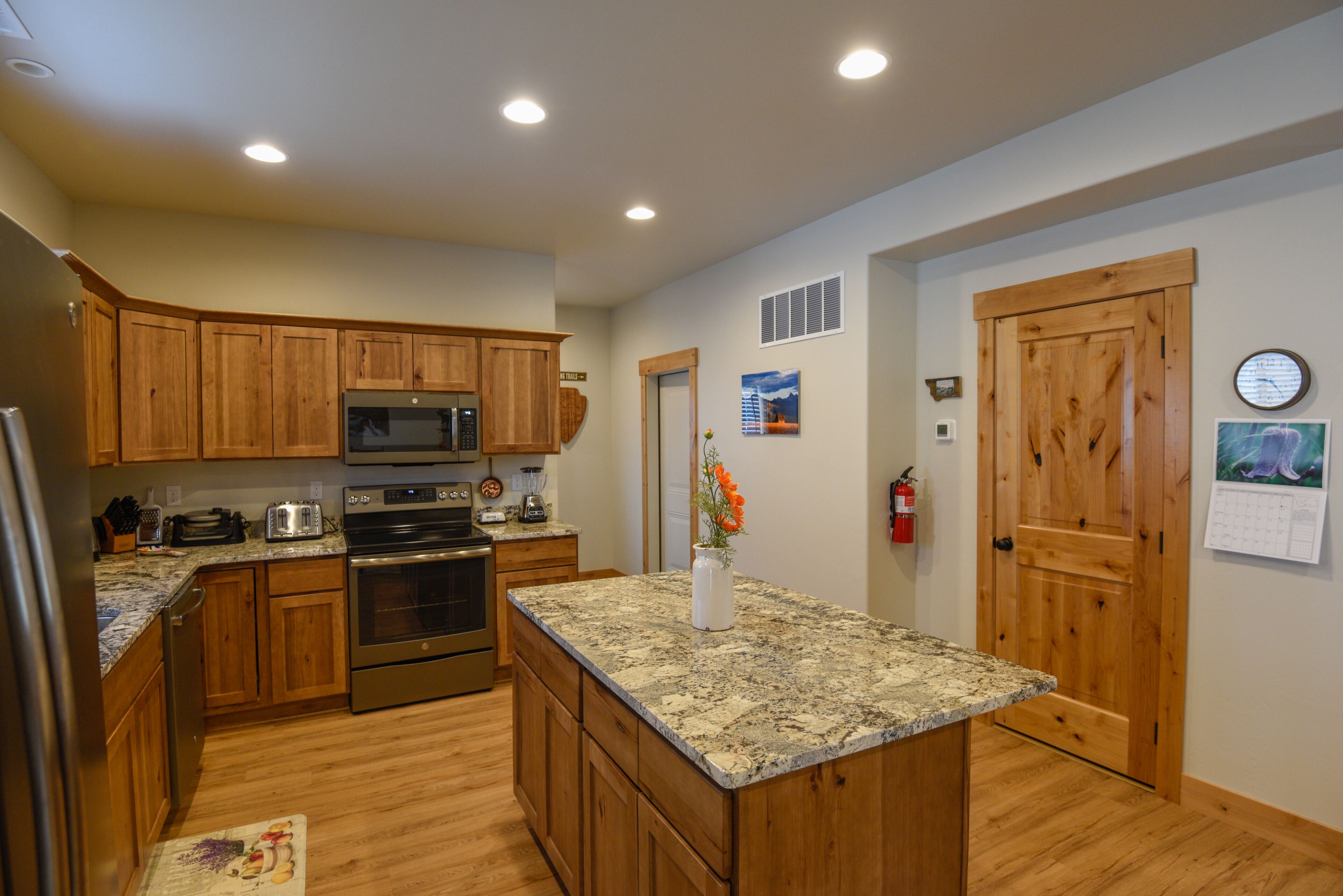 A kitchen with wooden cabinets, stainless steel appliances, and a granite countertop.
