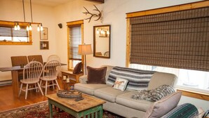 A cozy living room with a sofa, chairs, a coffee table, and a rug.