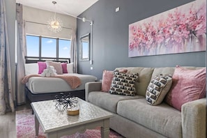 A bedroom with a bed, a sofa, a coffee table, and a large window. - Palace 2305 (Myrtle Beach)
