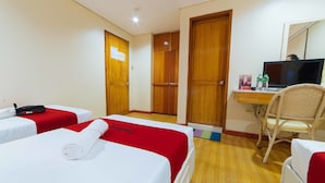 A hotel room with two beds, a desk with a computer, a chair, and a television. - RedDoorz @ The Manor Davao (Davao)
