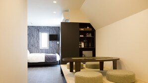 A modern hotel room with a bed, a small dining table, and ottomans. - CHA-AN Hotel Ueno (Tokyo)