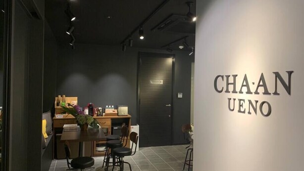 A modern interior with a dining area, a kitchen, and a sign reading "CHAAN UENO". - CHA-AN Hotel Ueno (Tokyo)
