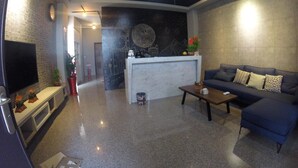 A modern living room with a sofa, a coffee table, a TV, and a fireplace. - Dan Blue B&B (Magong)