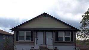 A two-story house with a gabled roof, a front porch, and a garage.