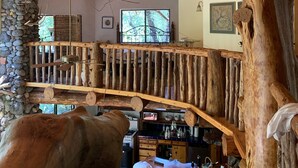 Un intérieur rustique avec un plafond en bois, un mur en pierre et un escalier en bois.