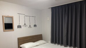 Une chambre à coucher avec un lit, un miroir et un motif décoratif sur le mur, ainsi que des lampes suspendues.
