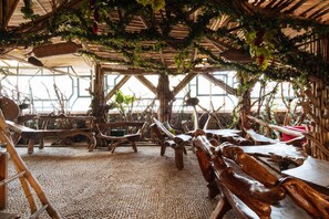 A rustic interior with wooden furniture and a natural, vine-covered ceiling. - RedDoorz Plus near Strawberry Farm Baguio (La Trinidad)