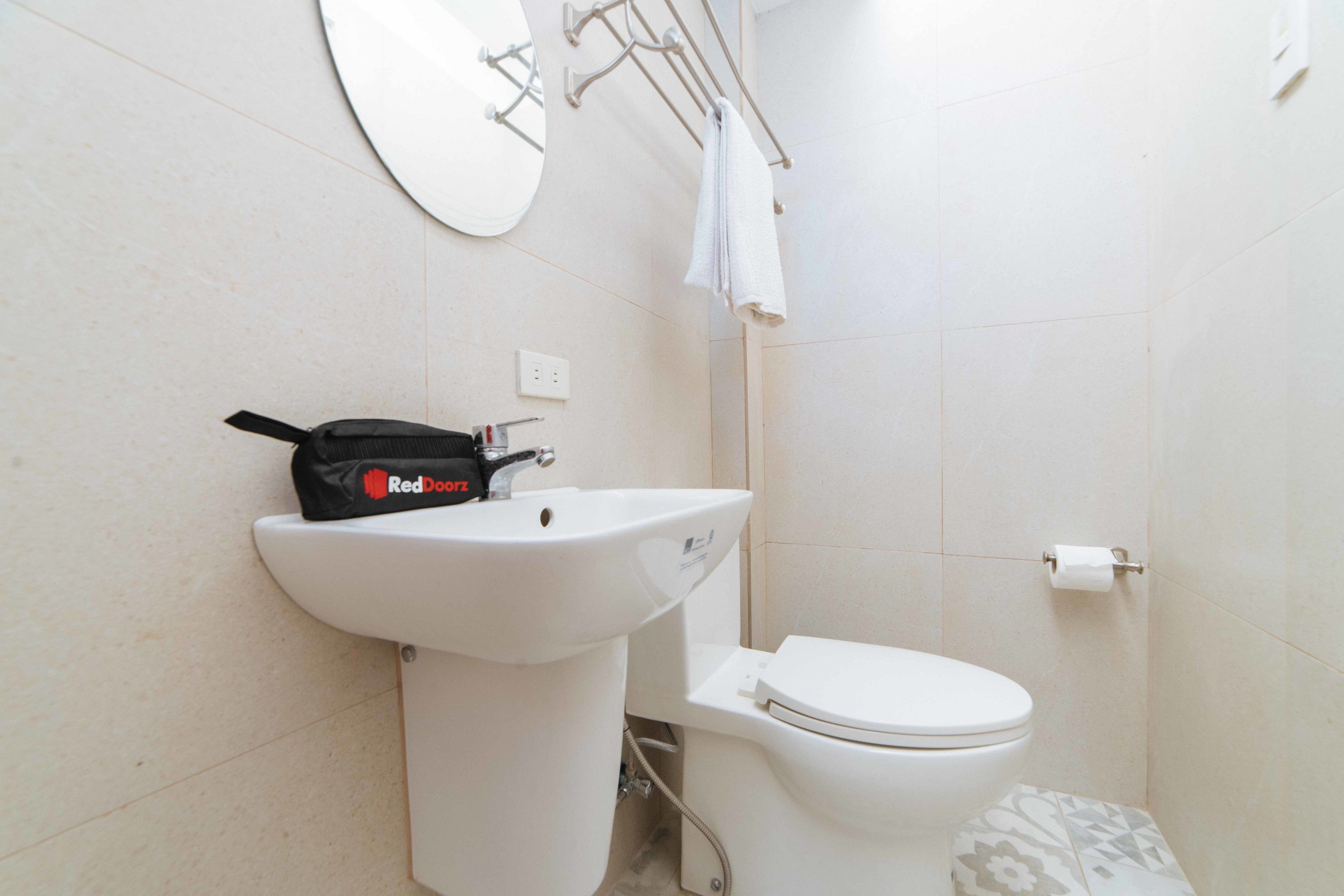 A bathroom with a white sink, toilet, and a towel rack.