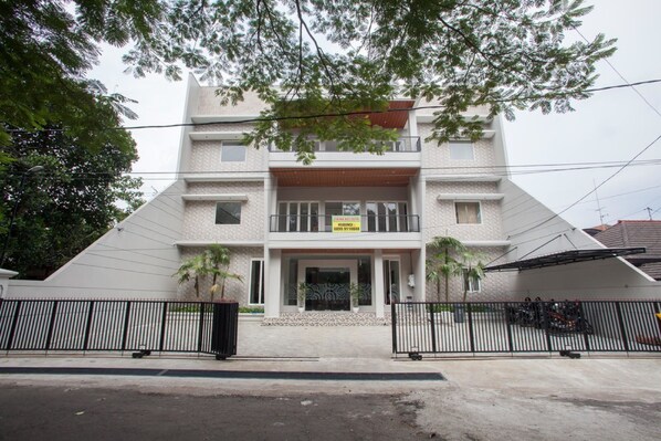 A two-story building with a gated entrance, a balcony on the second floor, and a sign indicating a business or office space. - RedDoorz Syariah near Universitas Negeri Malang (Malang)