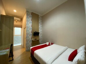 A hotel room with a bed, a desk, a TV, and a window. - RedDoorz Syariah near Universitas Negeri Malang (Malang)