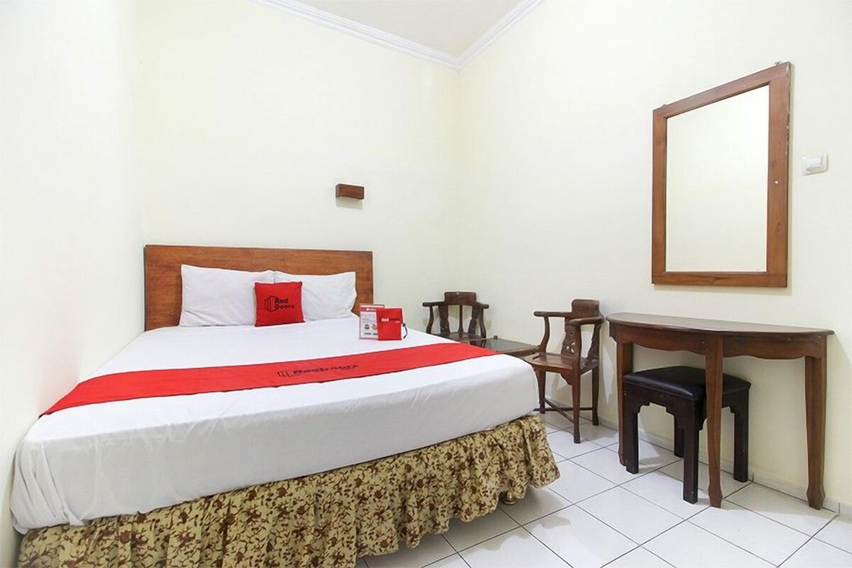 A hotel room with a bed, a desk, and a chair.