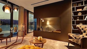 Una sala de estar moderna con una mesa de vidrio, un sofá y una estantería.
