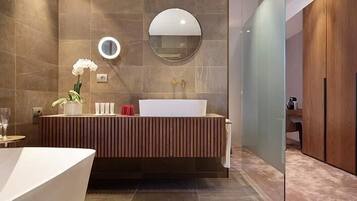 Ein modernes Badezimmer mit einer großen Badewanne, einem Waschtisch mit Spiegel und einem Holzbadezimmermöbel.