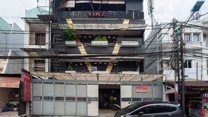 A multi-story building with a prominent 'VINZ' sign on the top floor. - RedDoorz Plus @ Kemayoran (Jakarta)