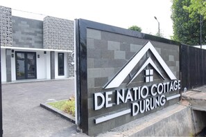 A sign for De Natio Cottage Durong with a modern design and a clear view of the entrance. - RedDoorz Plus near UNIMED Medan (Medan)