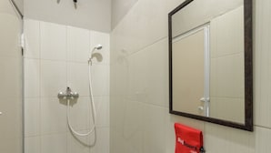 Ein Badezimmer mit Dusche, Waschbecken und Spiegel.