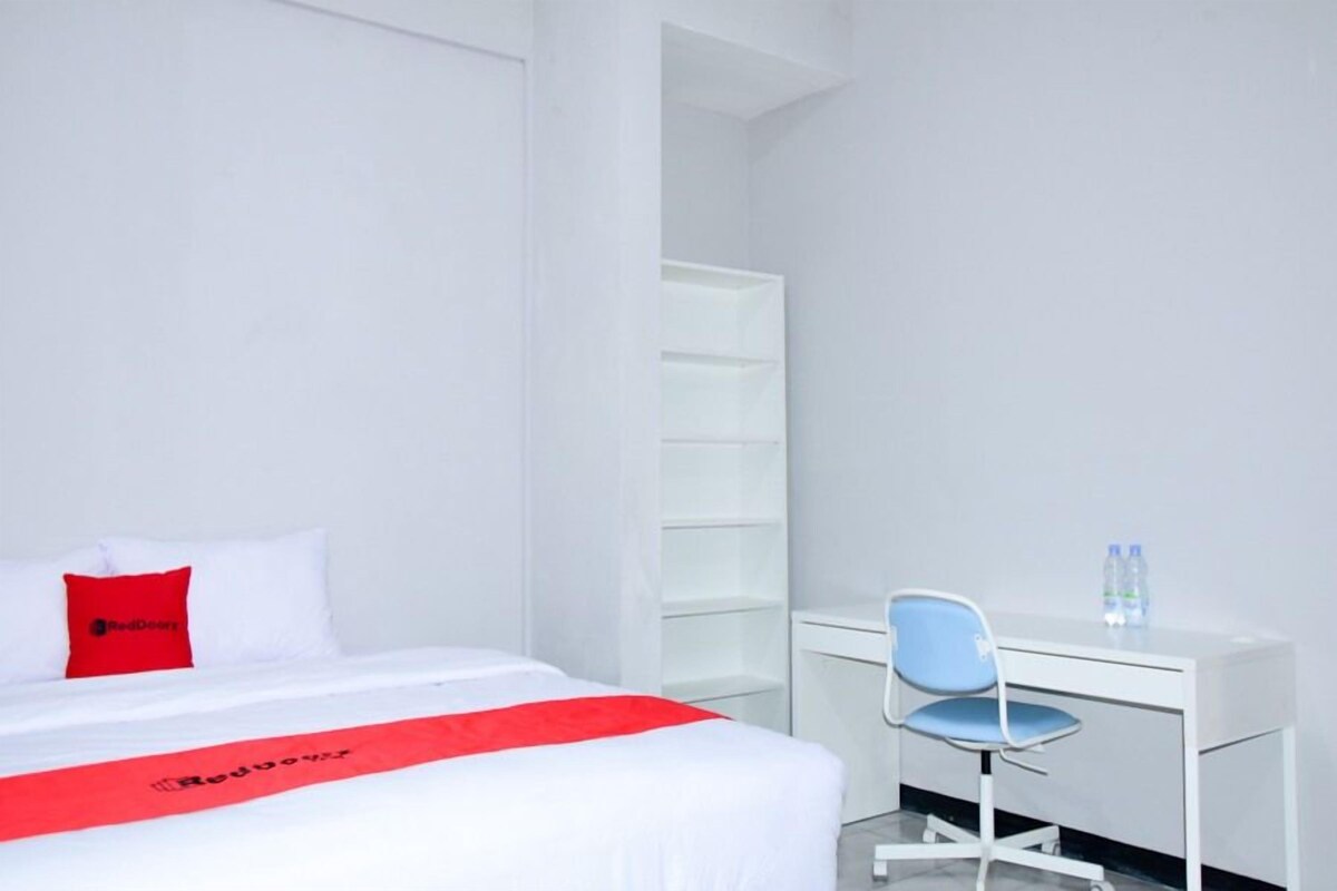 Une chambre d’hôtel avec un lit, un bureau et une chaise.