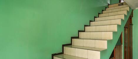 A staircase with a green wall and wooden doors.