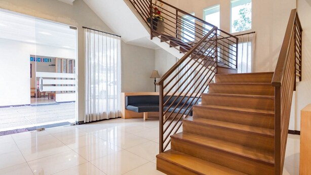 Een modern interieur met een houten trap, een zithoek en een lichte, ruime kamer.