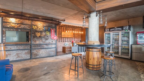 Una zona de bar con taburetes, barra y grifo de cerveza.