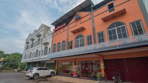 A building with a red and white facade, a sign for 'RedDoorz', and a motorcycle parked in front. - RedDoorz @ Batu Aji Batam 2 (Batam)