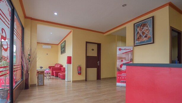 A hotel lobby with a reception desk, a fire extinguisher, and a framed picture on the wall. - RedDoorz @ Batu Aji Batam 2 (Batam)