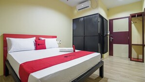A hotel room with a bed, a wardrobe, and an air conditioning unit. - RedDoorz @ Batu Aji Batam 2 (Batam)