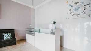 Un espace d’accueil au design moderne, doté d’une cloison en verre et d’un comptoir d’accueil blanc.