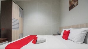 Une chambre d’hôtel avec un lit, une table de chevet, une armoire et un tableau au mur.