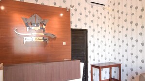 A reception desk with a wooden finish and a sign that reads "Guest House." - RedDoorz near Terminal A Adisucipto Airport (Kalasan)