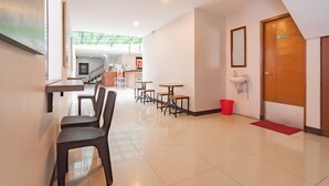 A hotel lobby with a reception desk, seating area, and a visible restroom. - RedDoorz Plus @ Dago Pojok 3 (Bandung)