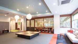 A modern interior with a tatami mat seating area, a sofa, and a small table.