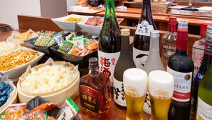A table with various food items, beverages, and condiments.