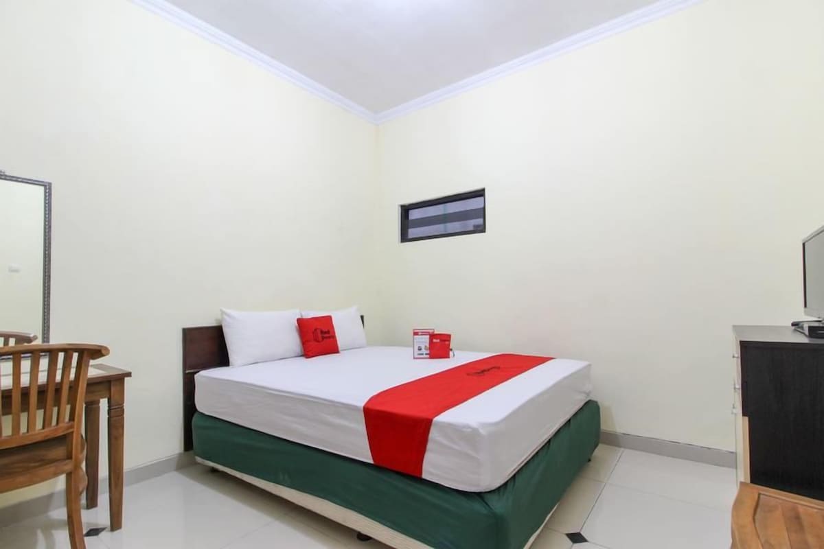 Une chambre d’hôtel avec un lit, un bureau et une chaise.