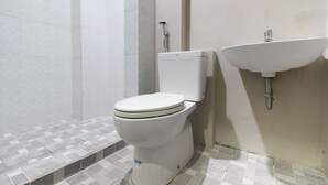 Un baño con inodoro, ducha y lavamanos.