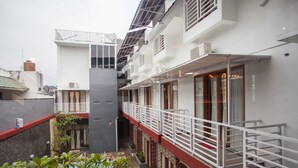 Un edificio moderno con varios balcones, un patio con plantas y una piscina.