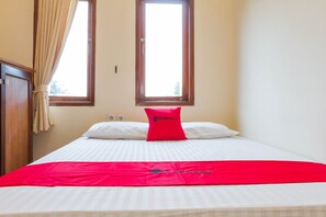 A hotel room with a bed, a window, and a wardrobe. - RedDoorz near Pasar Pagi Cirebon 2 (North Cirebon)