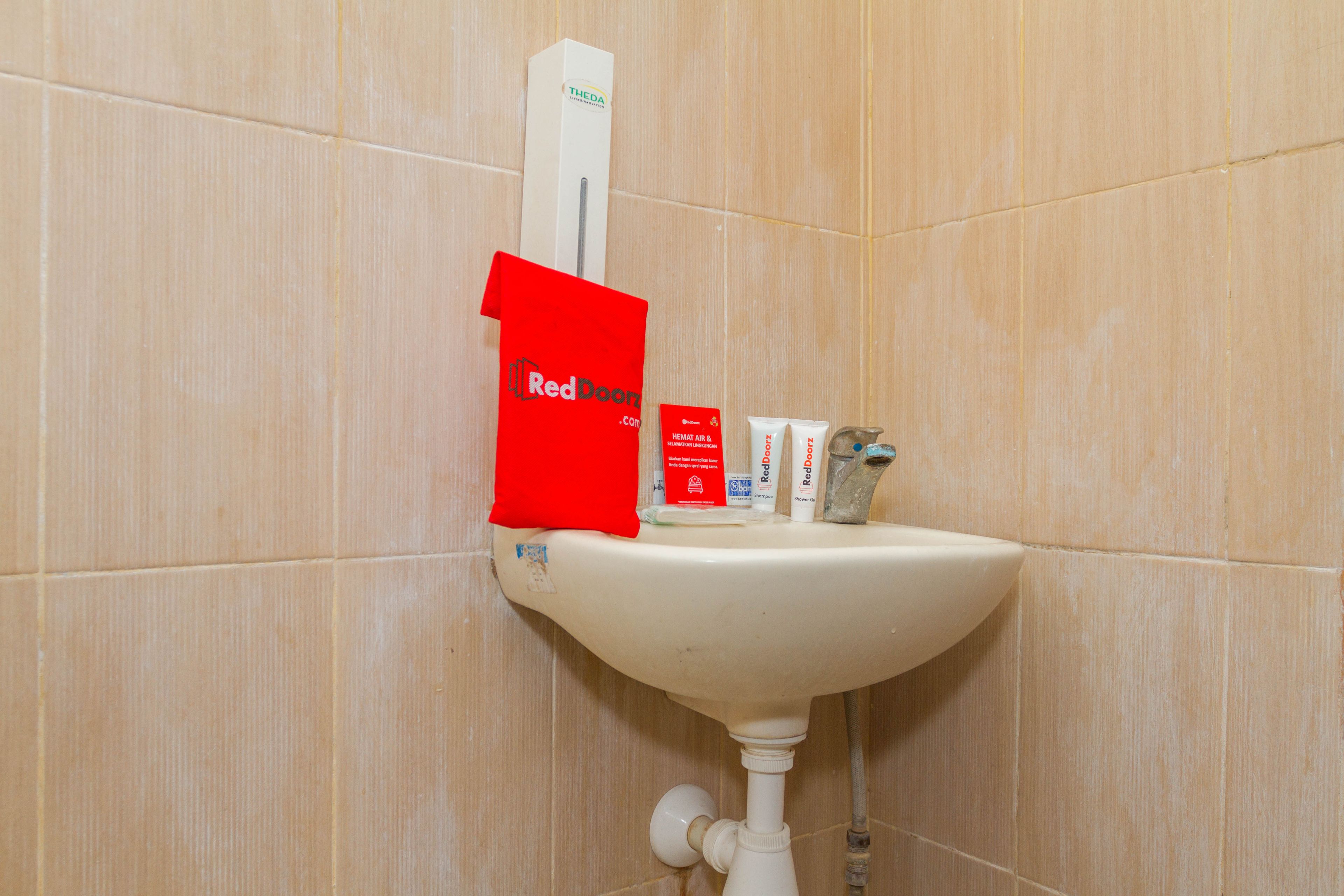 Ein Waschbecken mit einer roten Red Door Tasche, einer weißen Schachtel und einigen Pflegeprodukten.