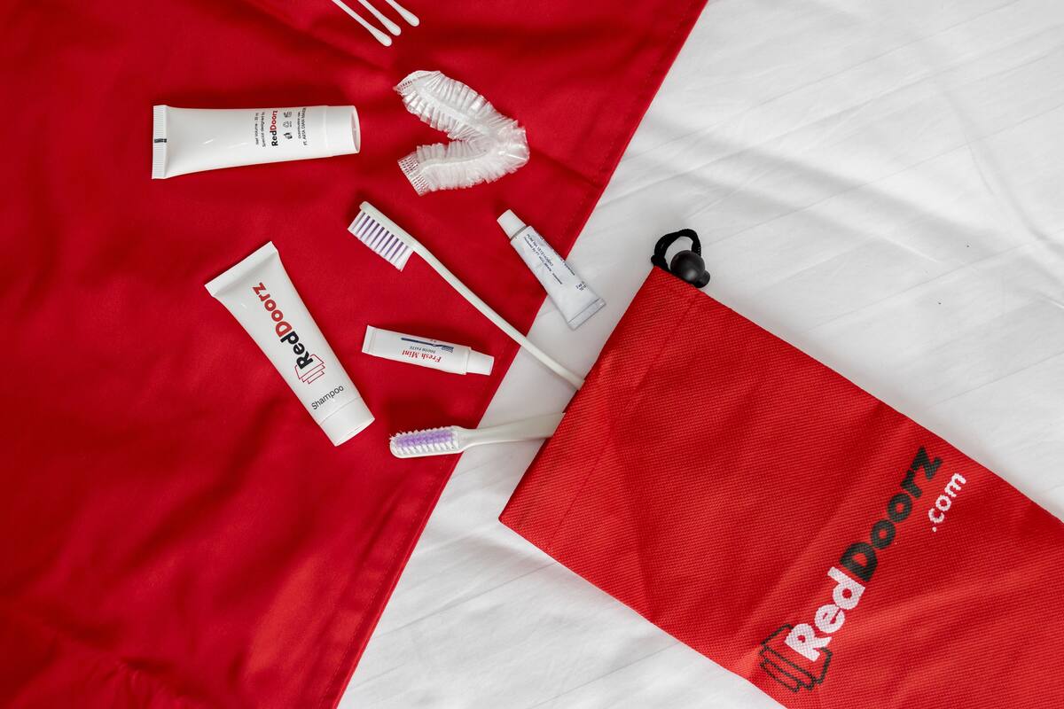 Un ensemble d’articles de soins personnels, soigneusement disposés, sur un fond en tissu rouge et blanc.