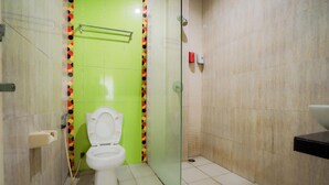Une salle de bain comprenant des toilettes, une douche à parois de verre et un lavabo.