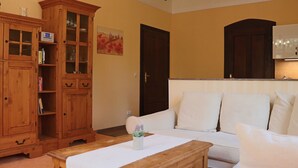 Una sala de estar con un aparador de madera, un sofá blanco y una mesa de centro de madera.